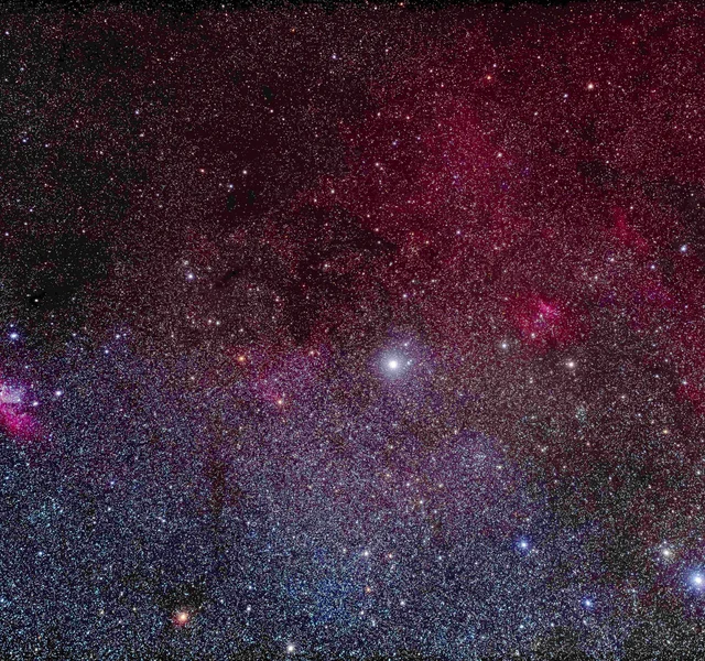 Sternennebel im südlichen Cepheus: dichtes Sternfeld mit rötlicher Nebelstruktur und farbigen Einzelsternen.