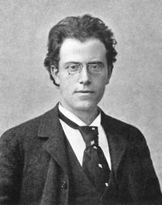 Junger Gustav Mahler, Porträt 1892: runde Brille, dunkler Anzug, Blick zur Seite.